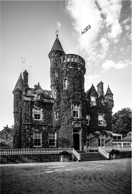 Carlowrie Castle in black and white, its ivy-clad tower flying the Scottish flag