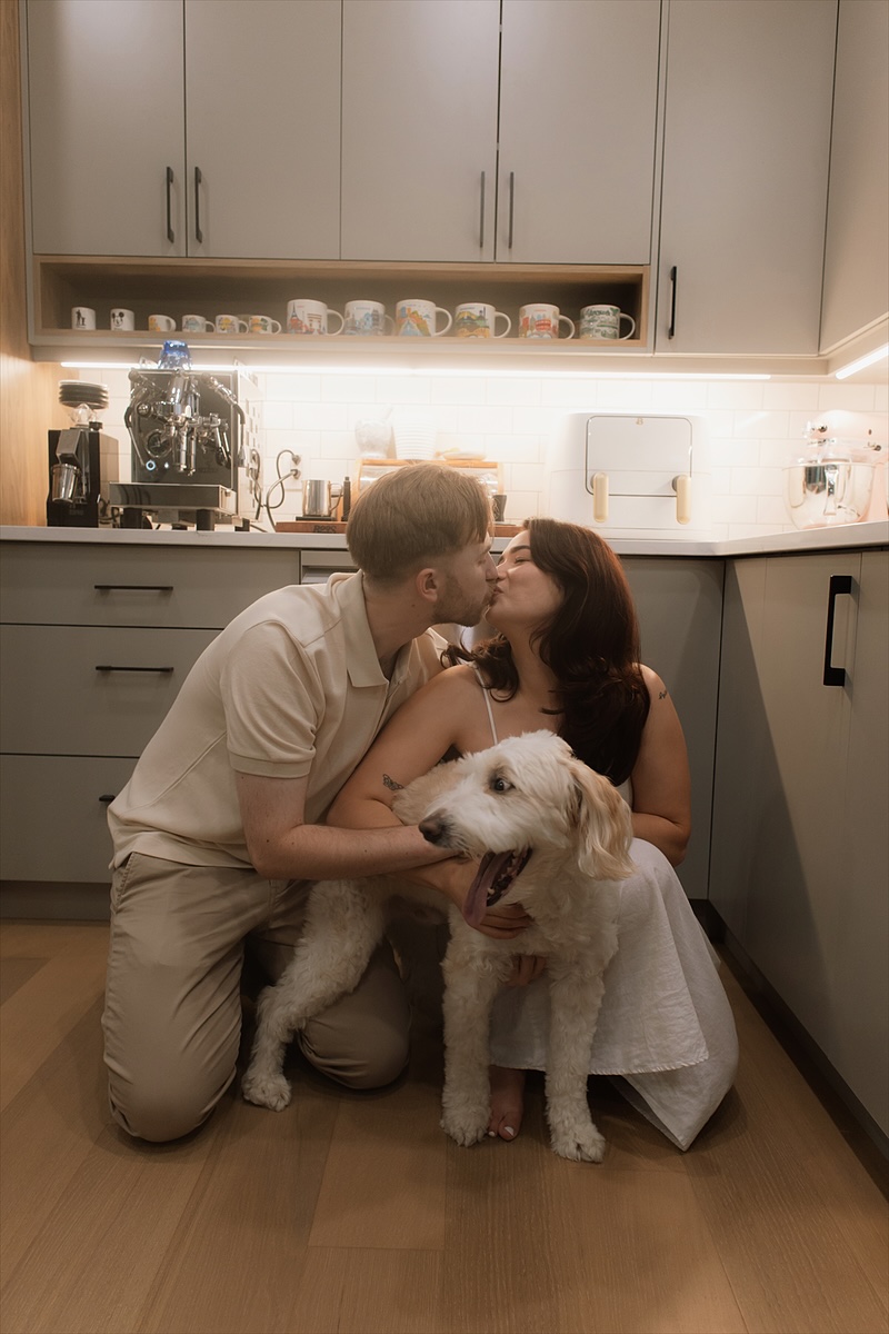 Kaylee and David kissing Monty in the kitchen