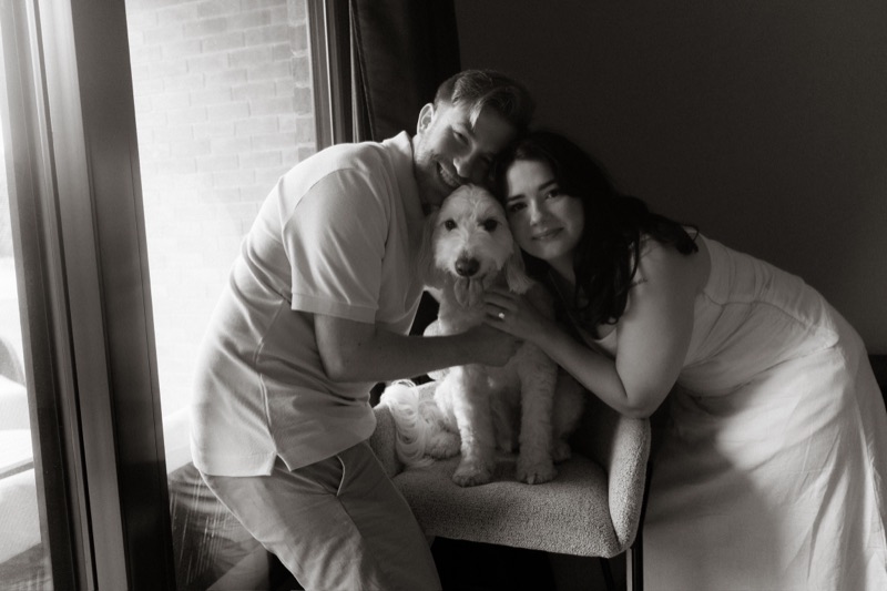 Kaylee and David at home with their dog Monty by a sunlit window